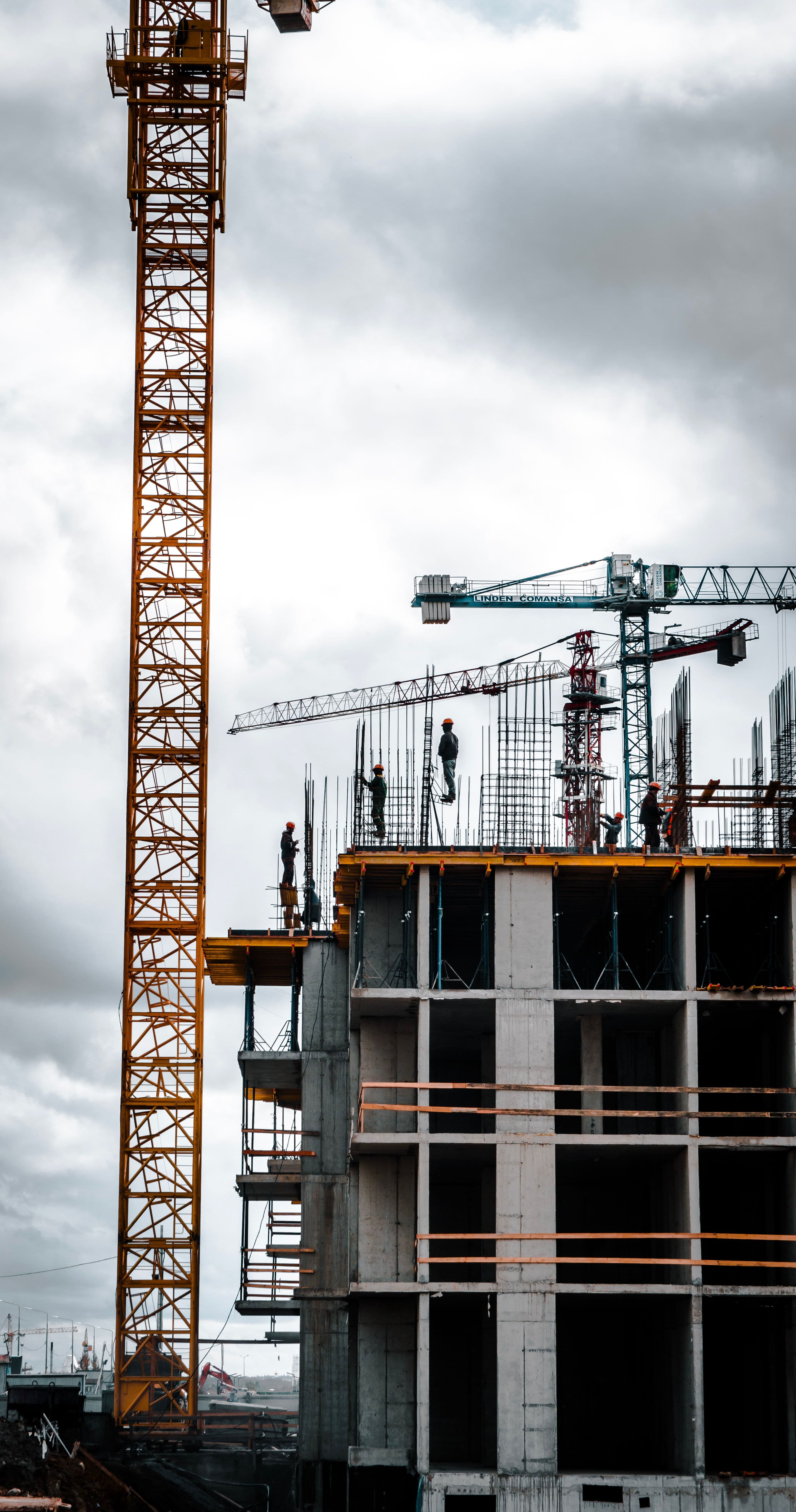 Active construction site with tower cranes and structural concrete work